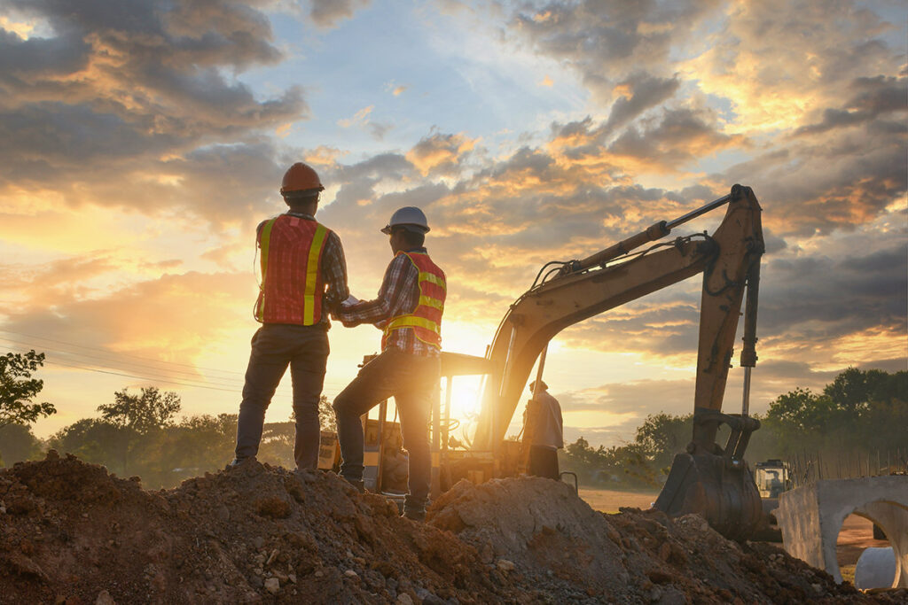 Construction engineers supervising the progress of a project at dawn.